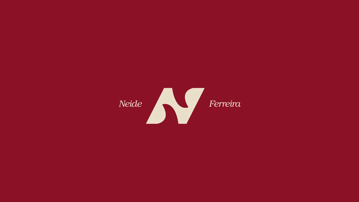 Abertura do book da Neide Ferreira: monograma N e assinatura sobre bordô