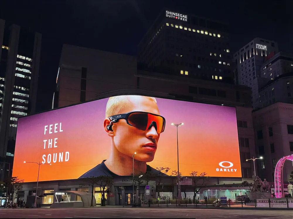 Tela de DOOH Feel the sound num prédio à noite